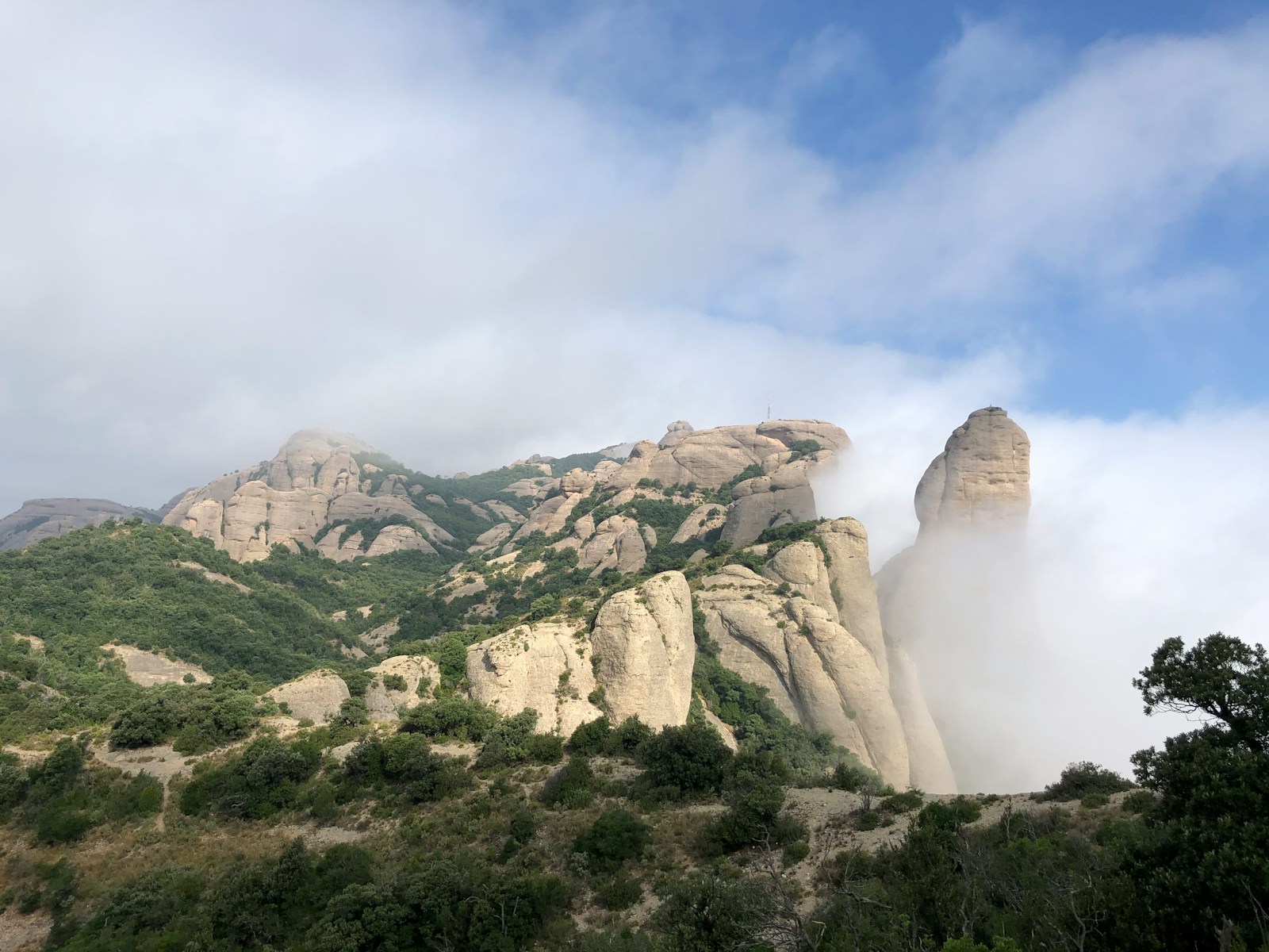 brown rocky mountain under white clouds during daytime